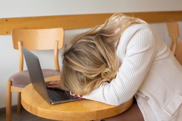 Beautiful girl freelancer feeling tired and stressed while using a laptop and working remotely.