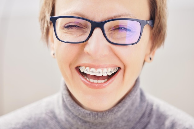 beautiful girl in glasses and braces smiling on a white background dentist orthodontist concept