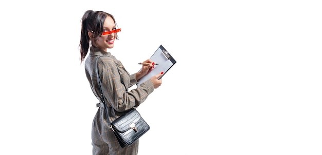 Beautiful girl in glasses makes a shopping list.