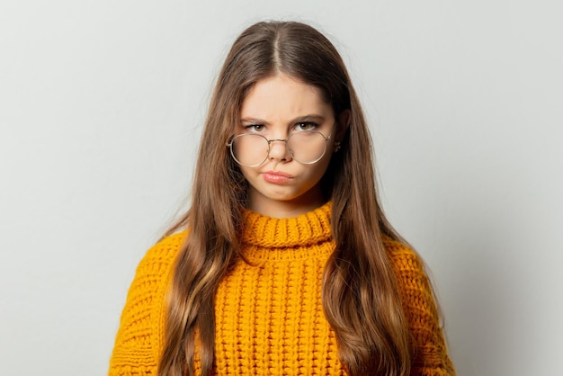 Photo beautiful girl in glasses and yellow sweater on white background