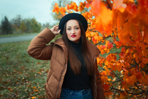 beautiful girl in a hat on the of the autumn landscape