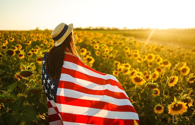 Beautiful girl in hat with american flag in sunflower field 4th of july fourth of july independenc