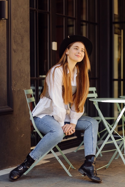 Bella ragazza che mangia caffè al caffè