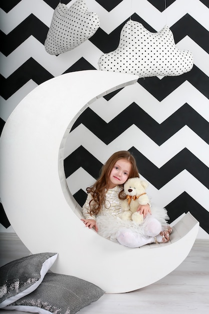 Beautiful girl in her room with the decor of the moon and clouds