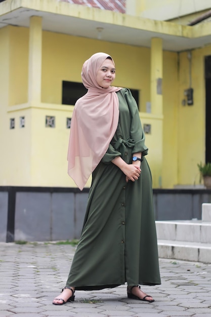 Beautiful girl in hijab wearing a green robe posing