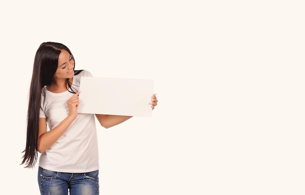 Beautiful girl holding a blank billboard