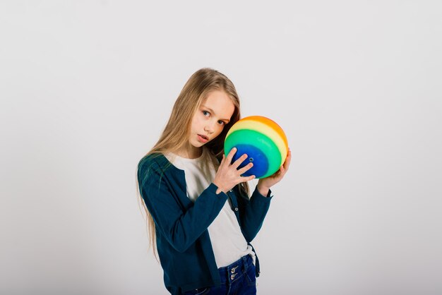 Bella ragazza che tiene palla luminosa colorata isolata su bianco, studio