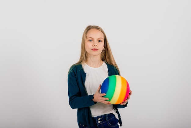 Beautiful girl holding coloured bright ball isolated on white