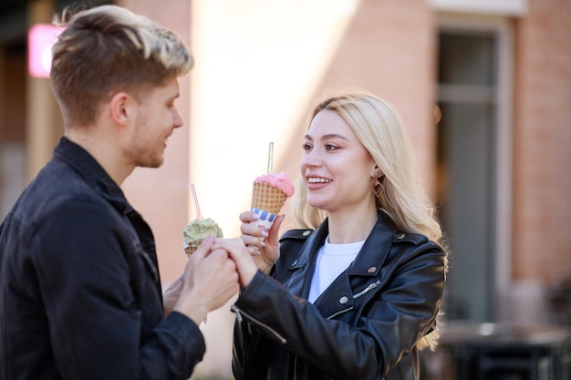 Bella ragazza che tiene il gelato e sorride al suo ragazzo