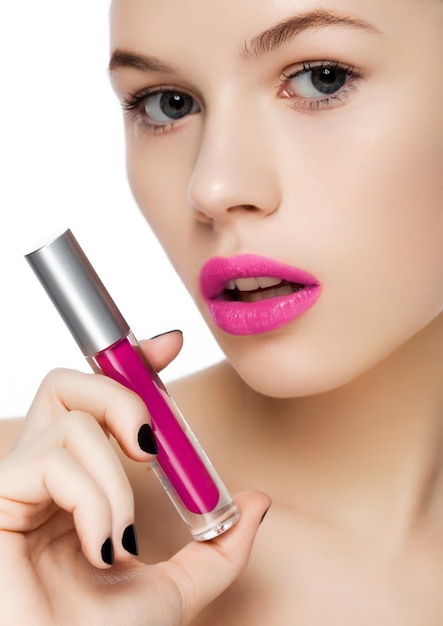 Beautiful girl holding liquid violet purple lipstick container tube on white background