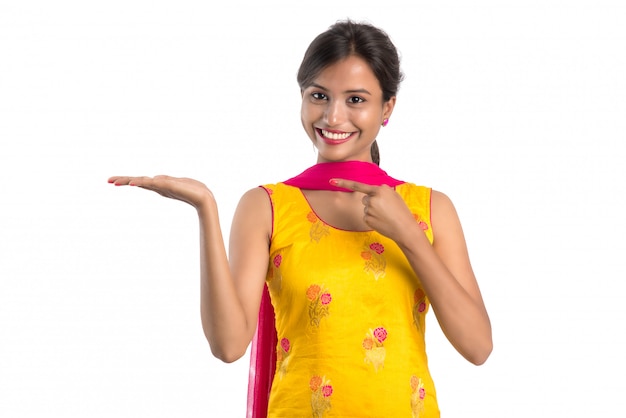 Beautiful girl holding and presenting something on the hand with happy smiling.