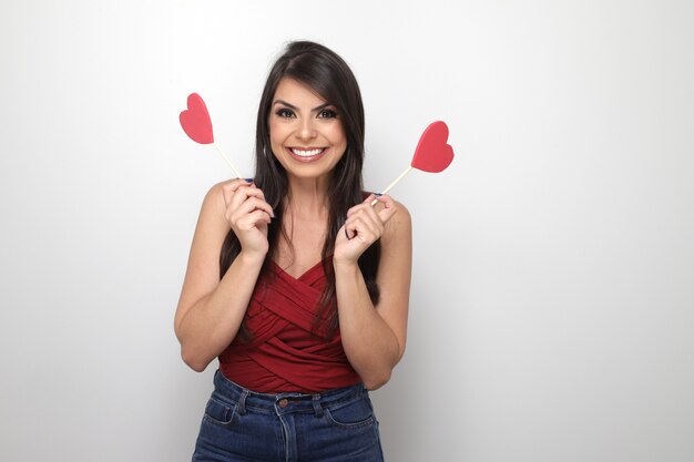 Beautiful girl holding valentine's gift on white background