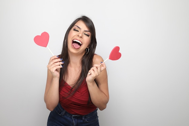 Beautiful girl holding valentine's gift on white background