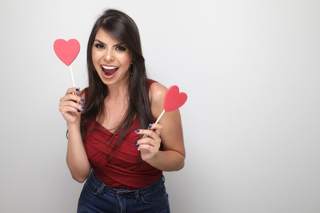 Beautiful girl holding valentine's gift on white background