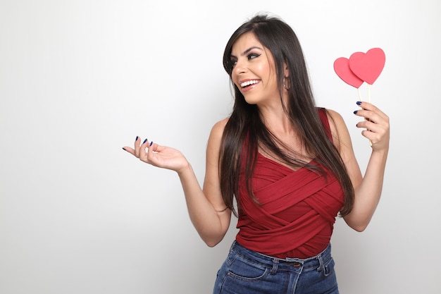 Beautiful girl holding valentine's gift on white background