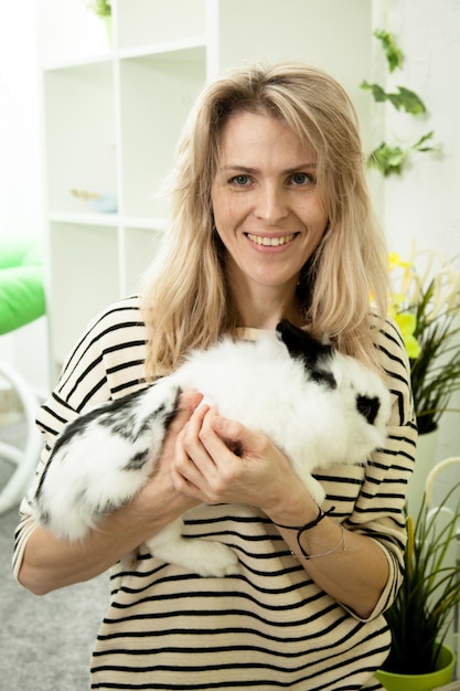 Foto bella ragazza che tiene un coniglio bianco sulle mani