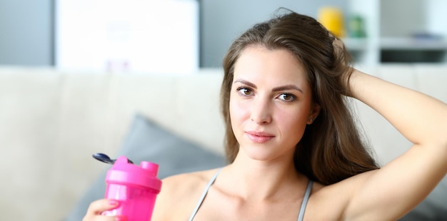 Beautiful girl holds sports water bottle training