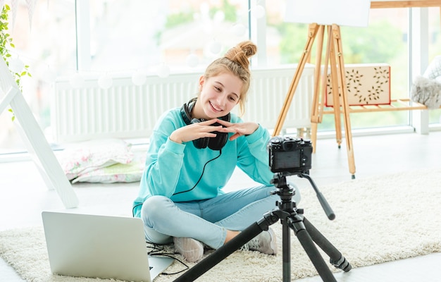 Beautiful girl hugging cute dog in front of camera on tripod