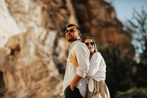 Beautiful girl hugging her man on top of mountain