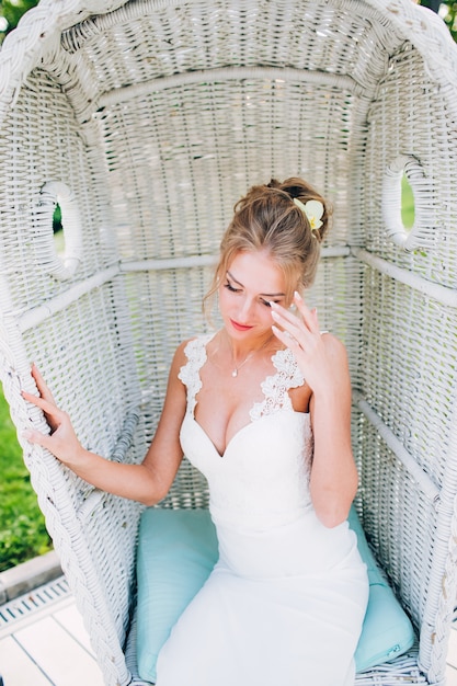 Фото Красивая девушка в белом стуле в природе. блондинка в платье с глубоким вырезом.