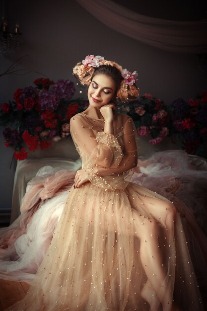 Beautiful girl is posing in a room full of flowers