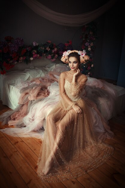 Beautiful girl is posing in a room full of flowers