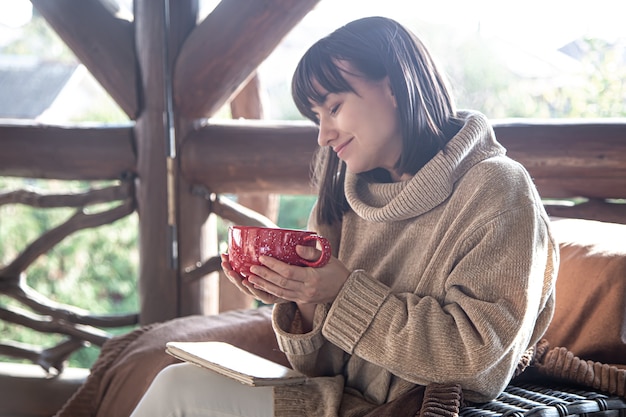 Beautiful girl is resting with a book and a hot drink. Outdoor recreation concept.