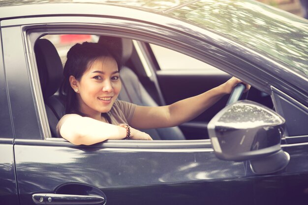 Beautiful girl  is smiling while driving a car