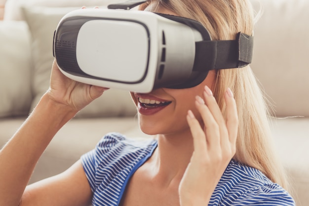 Beautiful girl is using virtual reality headset and smiling