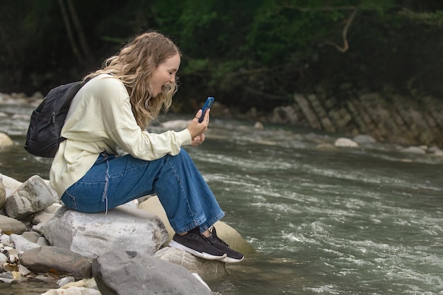 전화에 비명을 지르는 산 강 근처 여행에 아름다운 소녀
