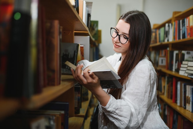 Bella ragazza in una biblioteca