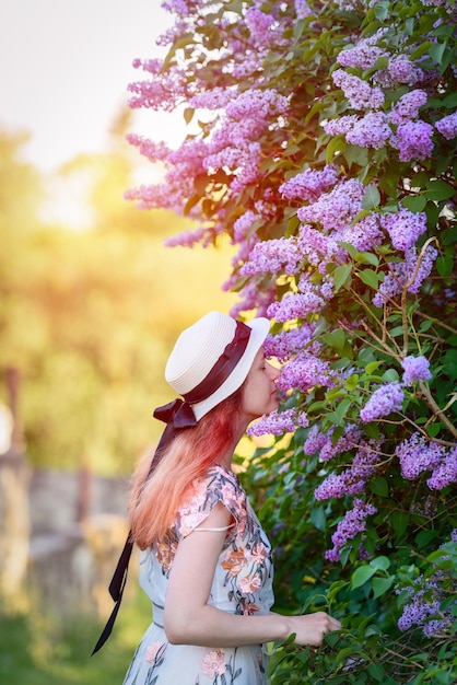 Bella ragazza alla primavera lilla bushsummer e al concetto di stile di vita