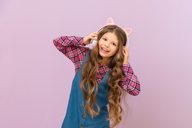 Photo a beautiful girl listens to an audiobook with headphones on an isolated background