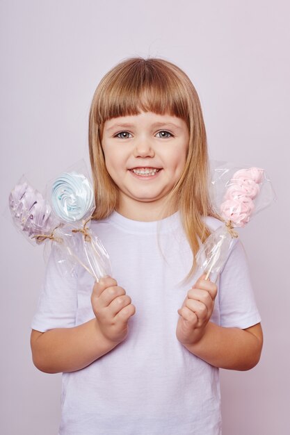 Foto i capelli lunghi della bella ragazza mangiano il caramello della lecca-lecca