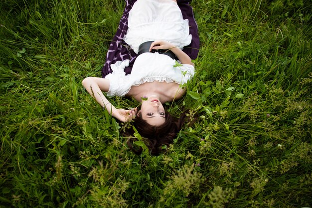 Beautiful girl lying down on grass. Soft focus