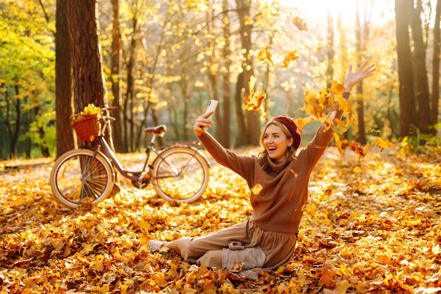 Beautiful girl makes a selfie in the autumn park