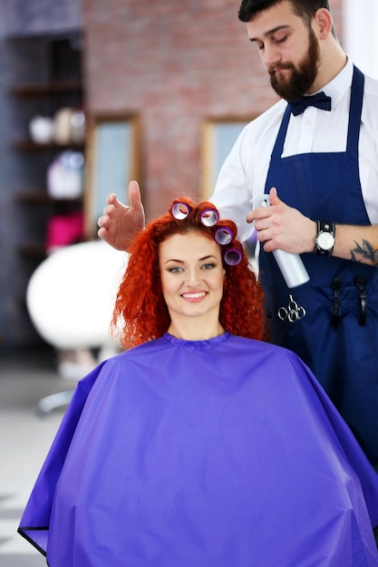 Beautiful girl making curlers in hairdressing salon