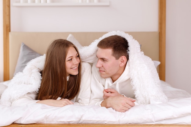 Beautiful girl and man in a blanket at home together