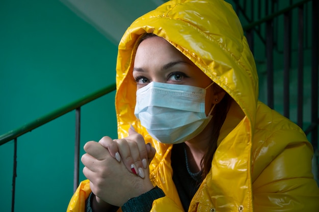 Beautiful girl in medical mask in an isolated abandoned building quarantined