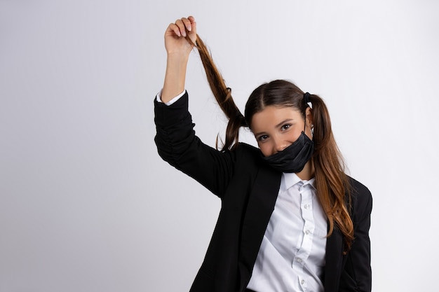 Beautiful girl in medical mask posing on a white wall new normal concept