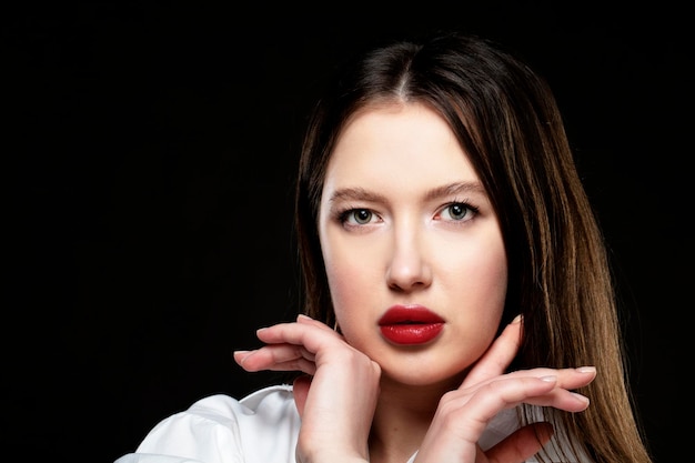 Beautiful girl model with red sensual lips on a black background