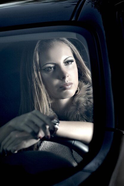 beautiful girl near a black car