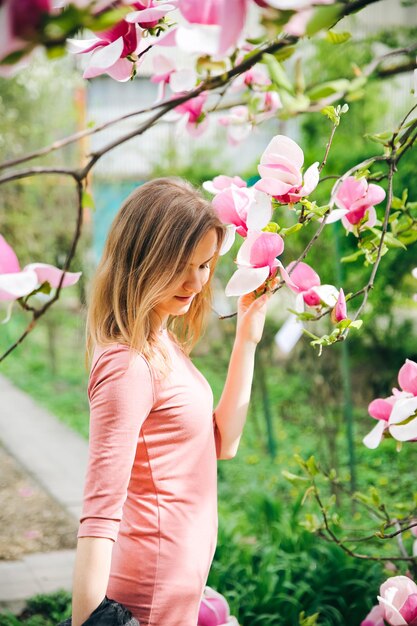 Beautiful girl near blooming tree Blossom magnolia outdoors Spring mood Woman relaxing