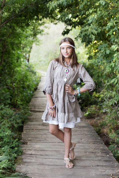 Beautiful girl on old wooden bridge in forest