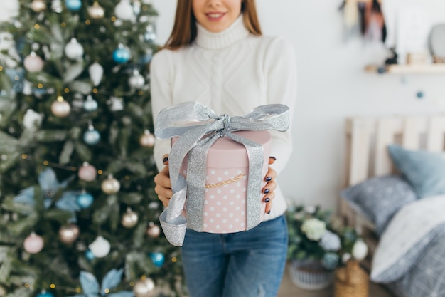 A beautiful girl opens Christmas gifts.