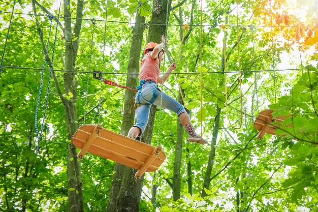 Beautiful girl in the park on the ropes achieve Outdoors