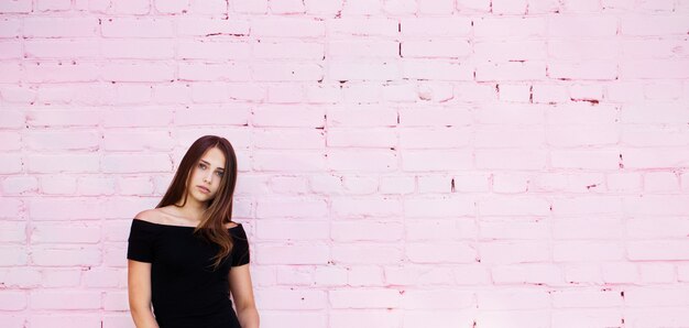 Beautiful girl on pink brick wall