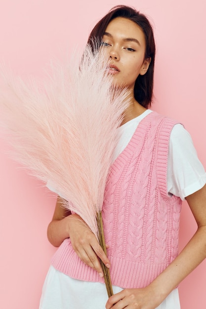 Beautiful girl in a pink vest with feathers in his hands Lifestyle unaltered