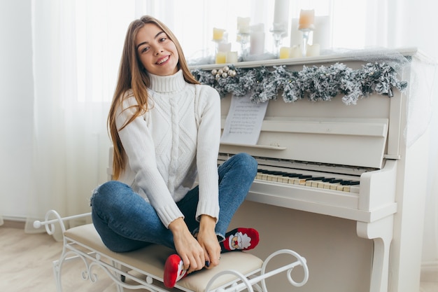 A beautiful girl play the piano on Christmas Day.