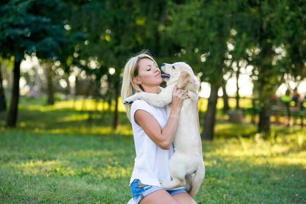 子犬のラブラドールと遊ぶ美しい少女